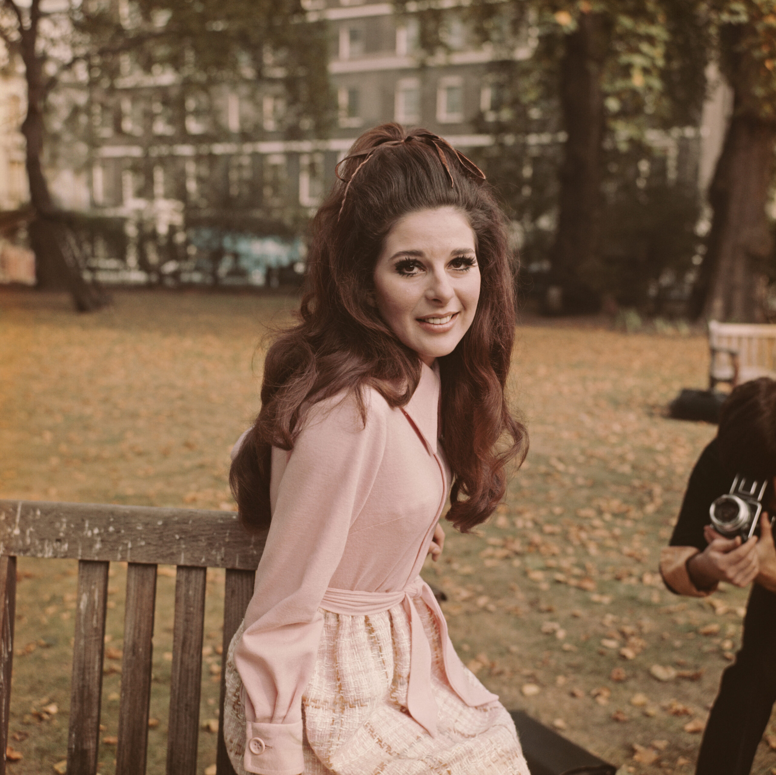 American singer and songwriter Bobbie Gentry posed sitting on a park bench in a London square on 13th October 1969