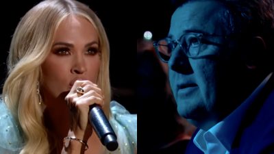 Vince Gill looks on as Carrie Underwood sings his song "Go Rest High On That Mountain"